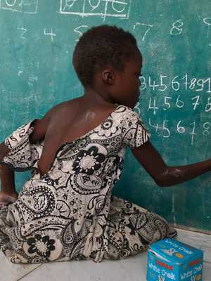 Girl writing on chalkboard in Brazzaville, Congo