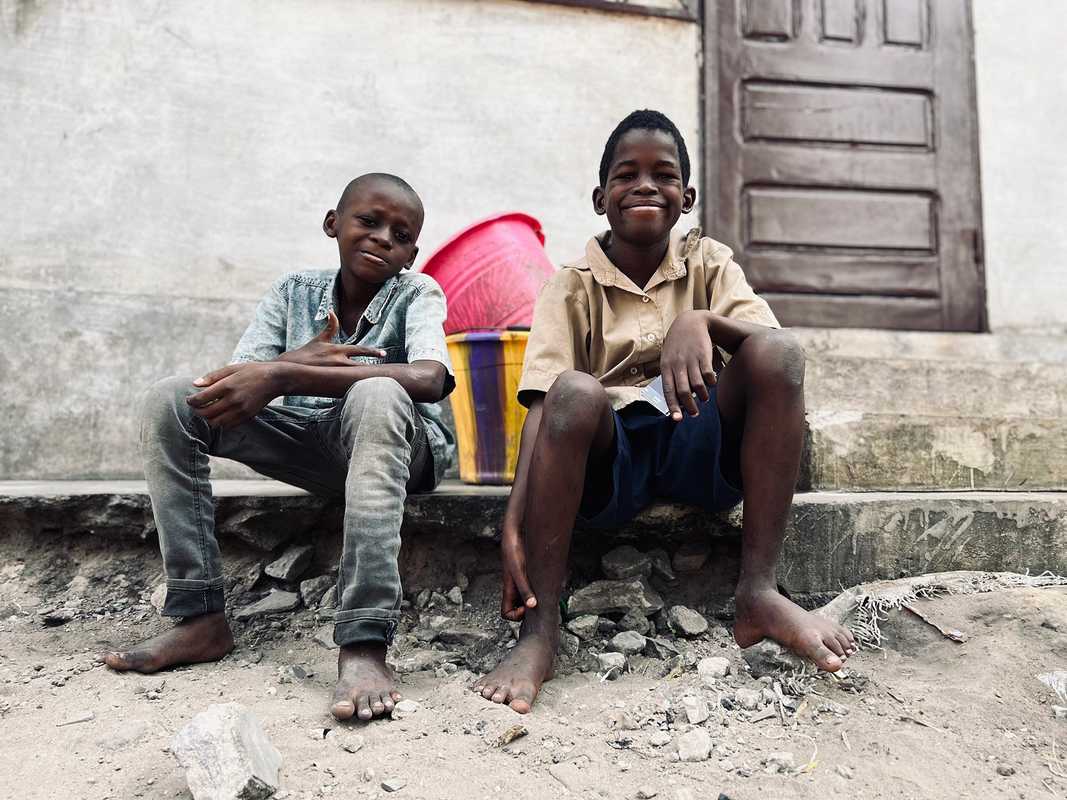 boys sitting on a curb in the Congo