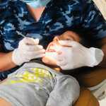 Misrael Hernandez performing dental work on a child
